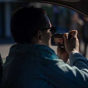 Man taking a photo from inside a car.