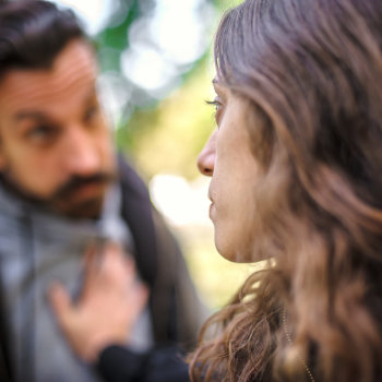 Two people engaged in a conversation outdoors.
